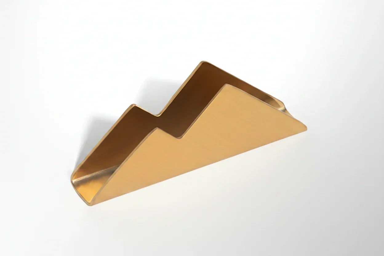 Gold mountain-shaped business card holder on a white background