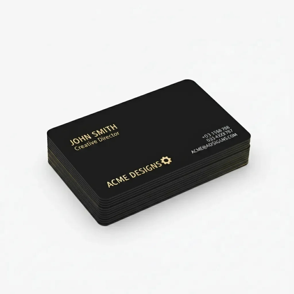 Stack of custom black business cards with gold text on a white background