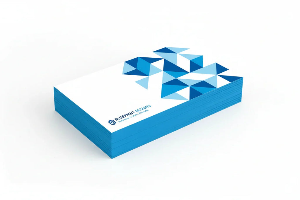 Stack of thick rectangular business cards with blue painted edges and geometric blue design on white background