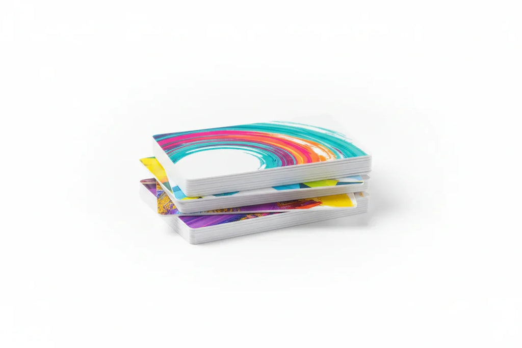 Stack of white PVC plastic business cards with vibrant color printing on white background