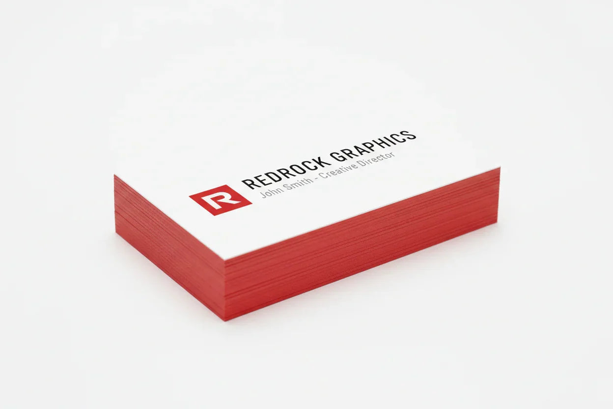 Stack of custom red edge business cards with white front and PMS 186 red sides on white background