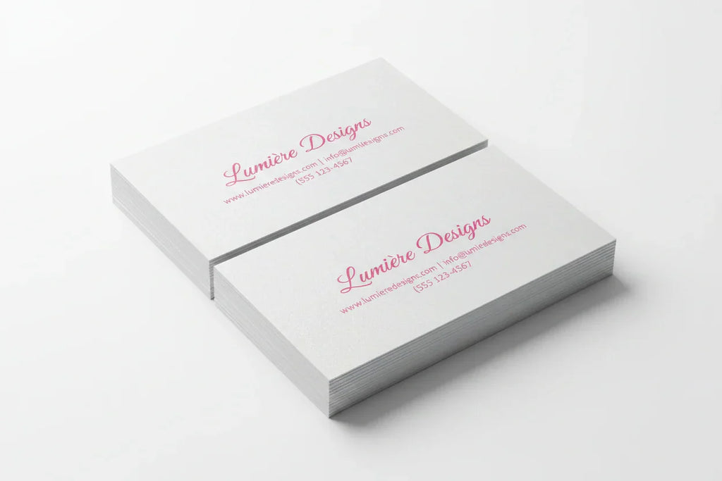 Stack of rectangular business cards with pink print on pearl paper, white background