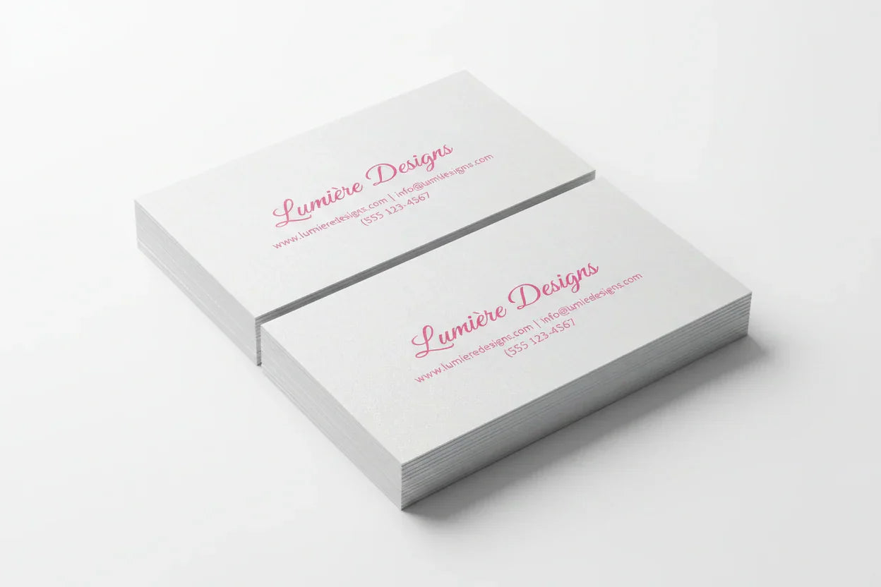 Stack of rectangular business cards with pink print on pearl paper, white background