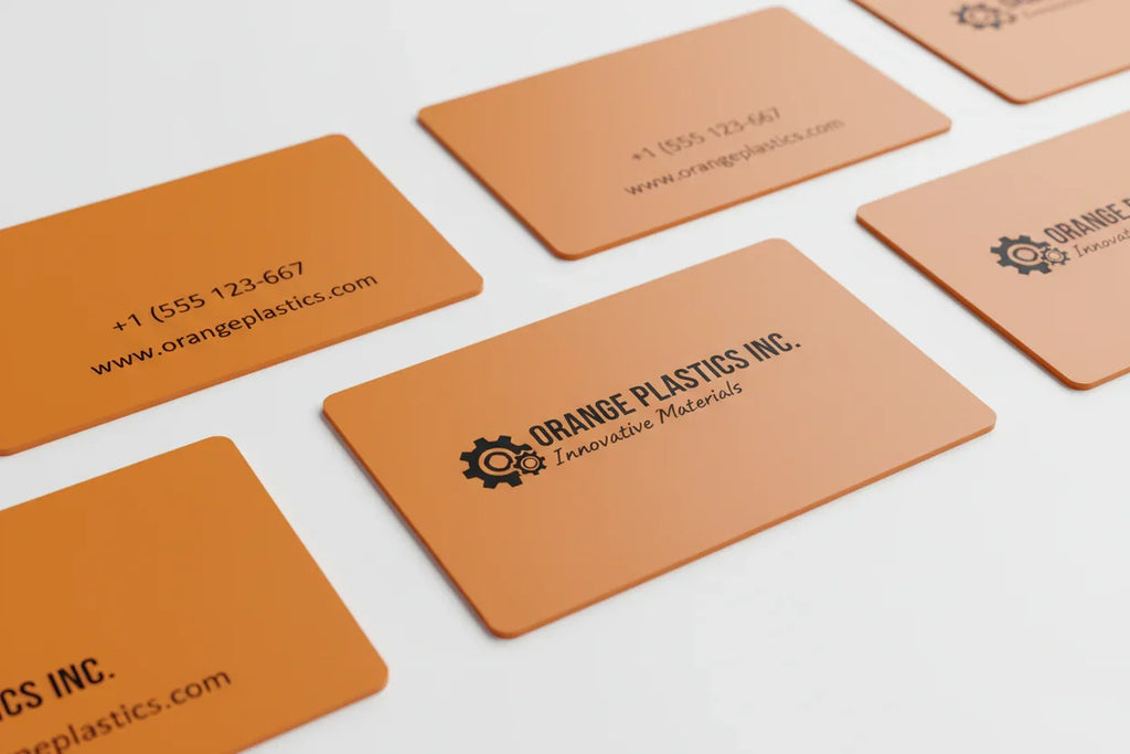 Opaque orange plastic business cards with black text on white background