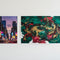 Two color posters, one small cityscape and one larger abstract art, on a white wall.
